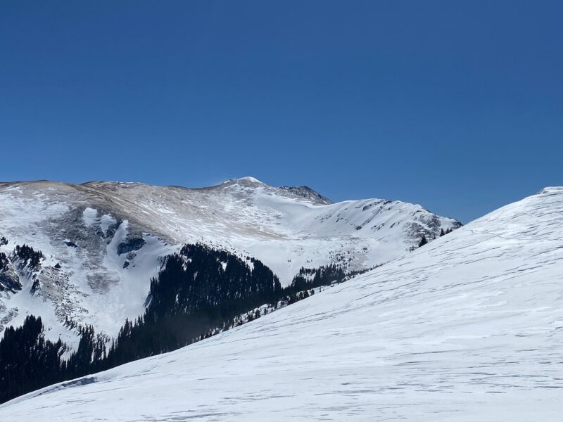 A good example of how the strong winds over the last several days have stripped and scoured west facing terrain with snow remaining on East and North aspects