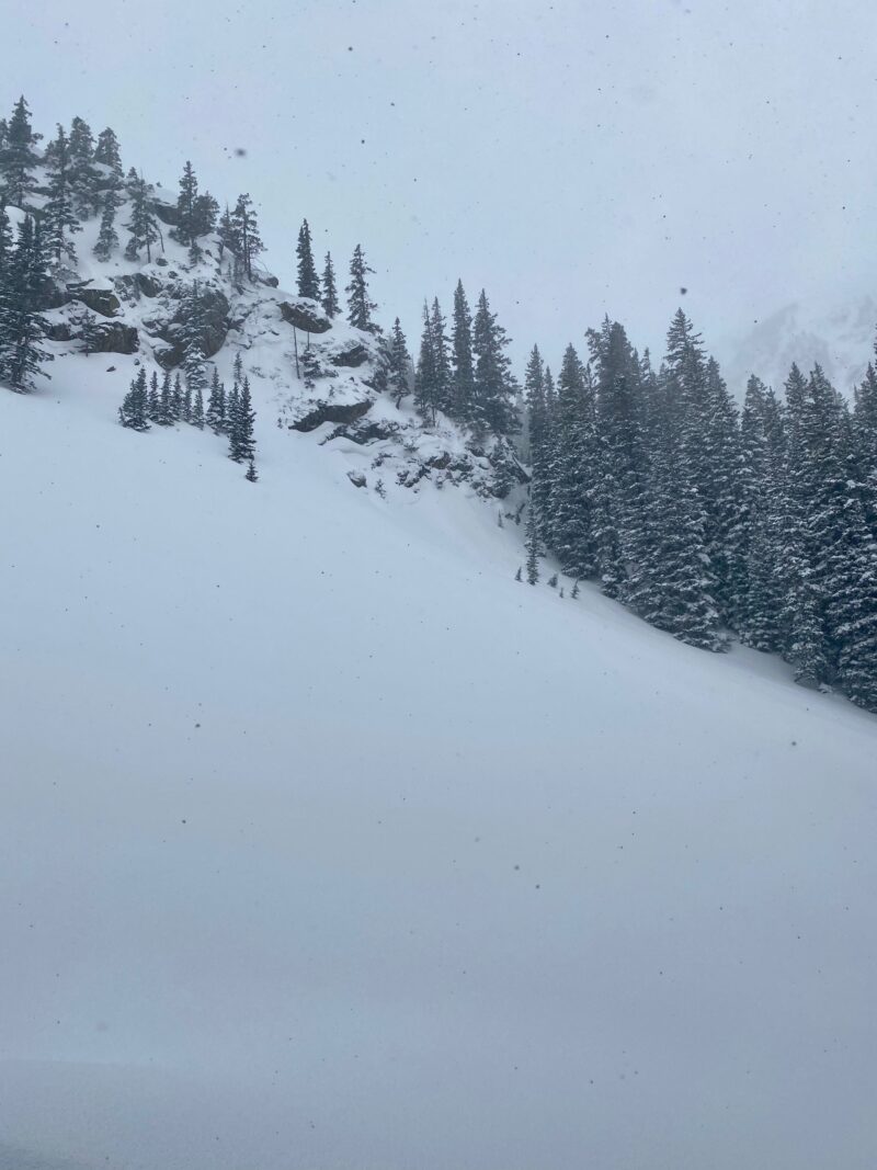 Small natural avalanche on steep terrain below the rock band